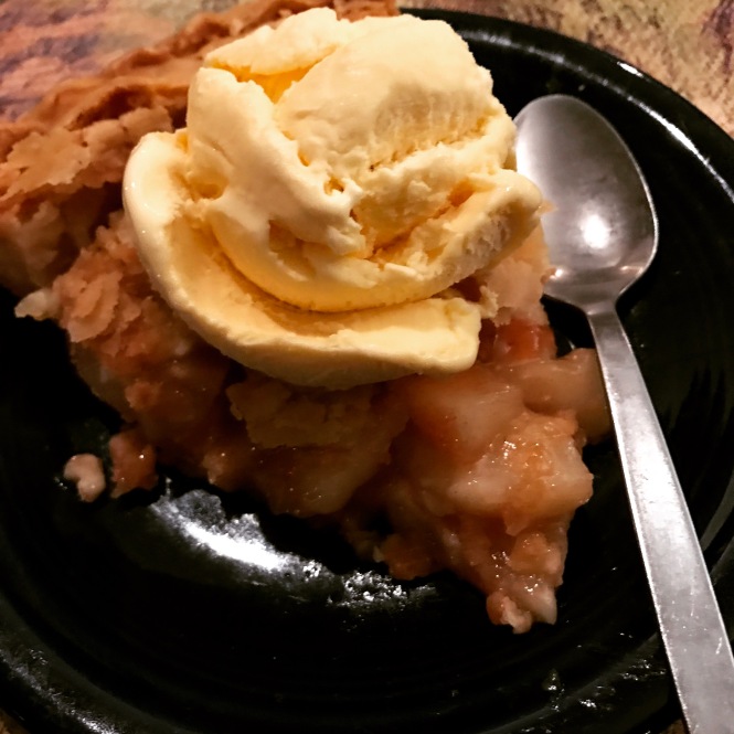 A slice of apple pie and a scoop of vanilla ice cream.